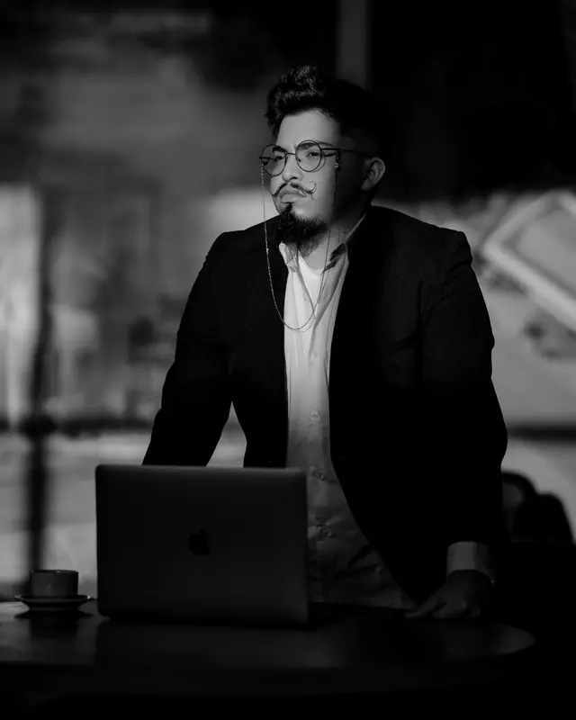 Maurício Waldeck em pé diante de um notebook